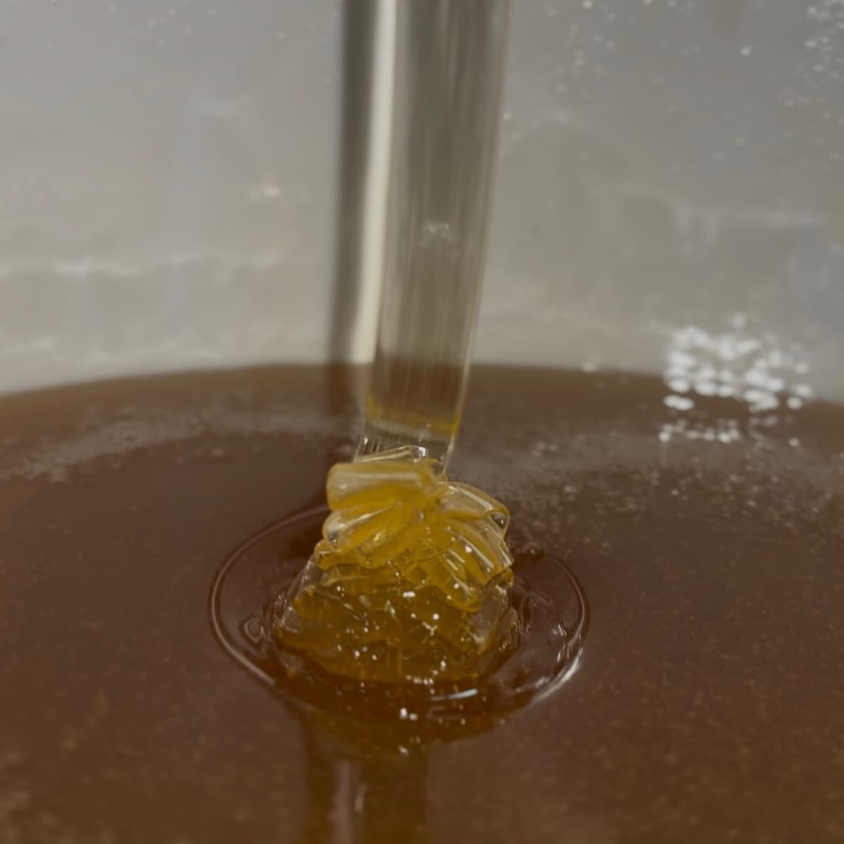 Miele di eucalipto Rosa D'Oro che scorre e mostra la sua naturale cremosità